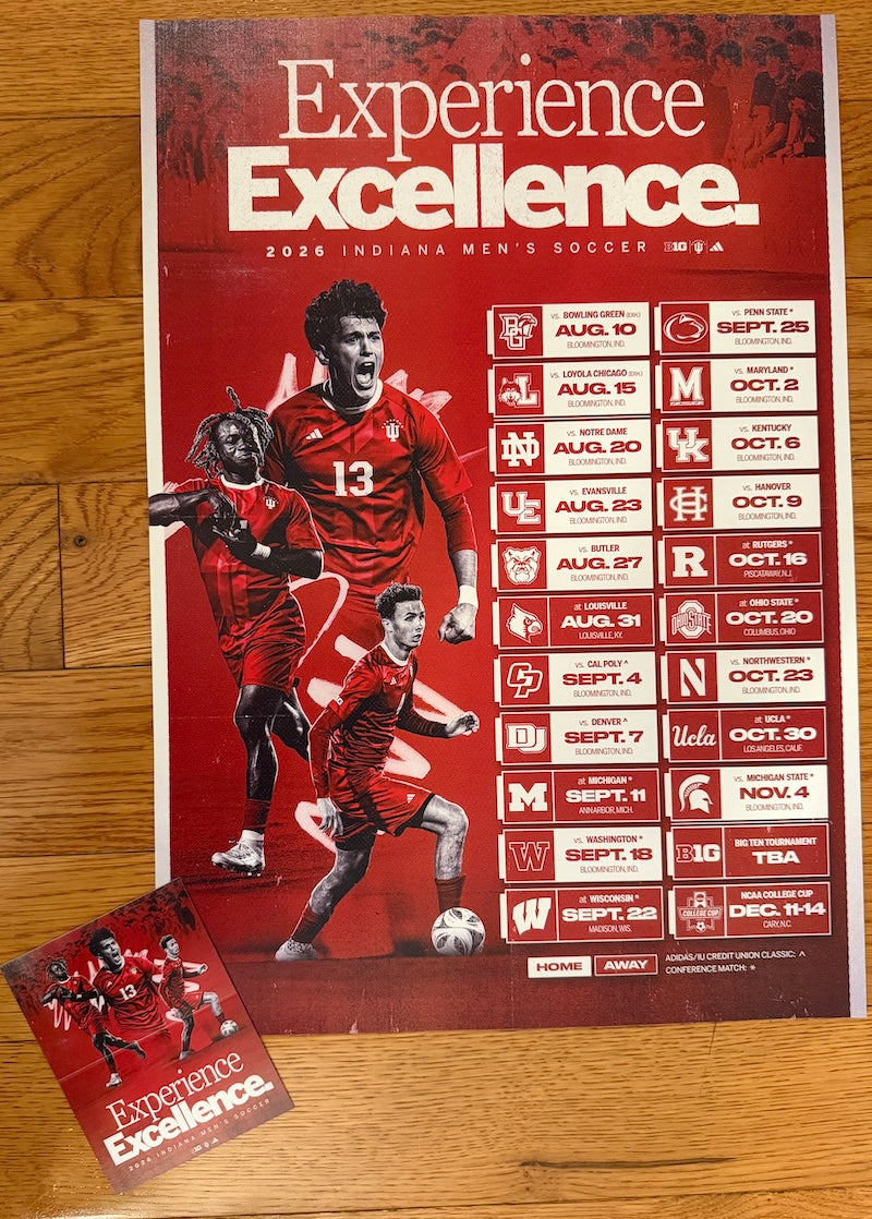 A red and white 2026 Indiana Men's Soccer 'Experience Excellence' poster laid flat on a wooden floor, with a smaller matching card placed in front of it.