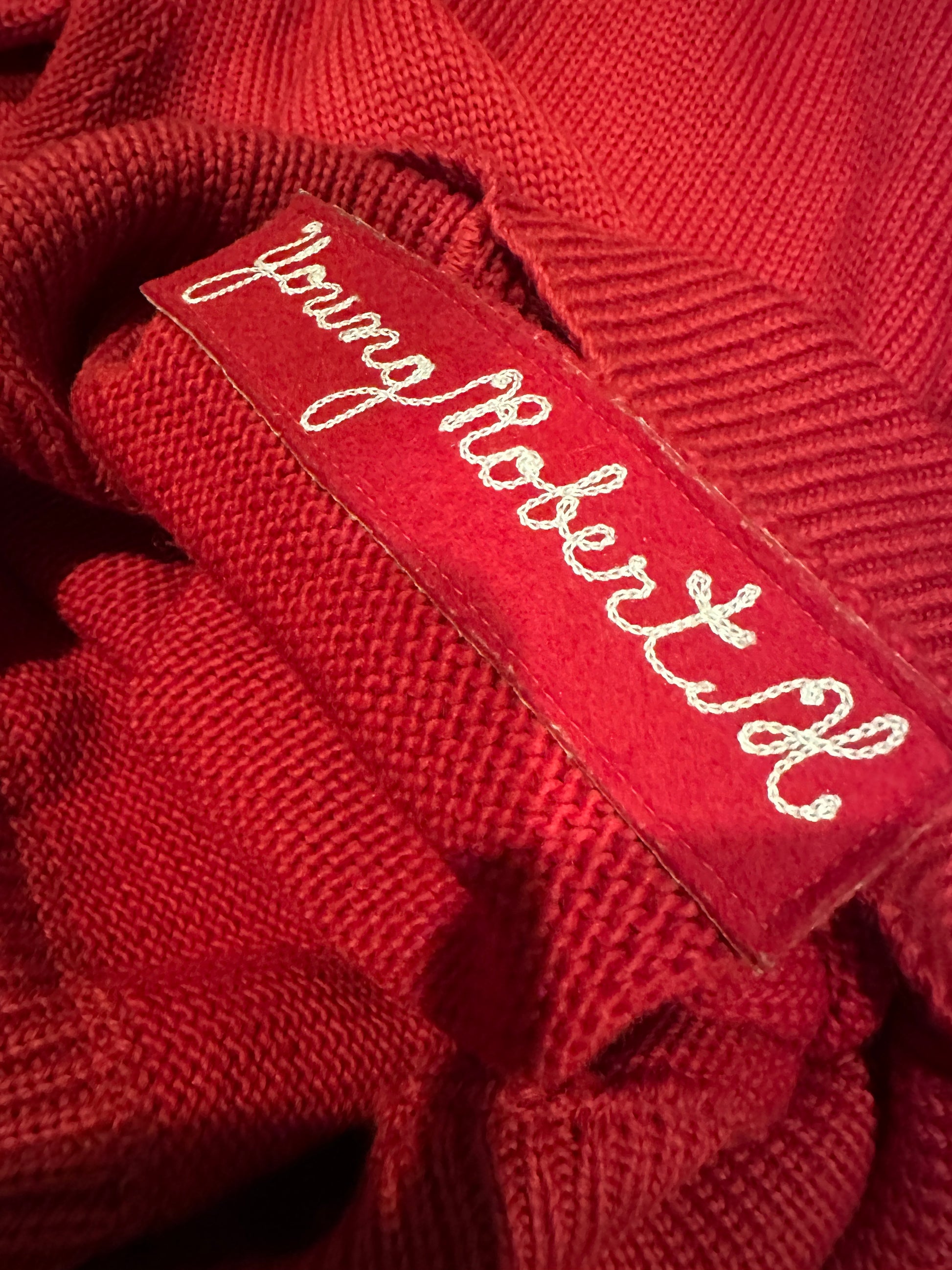 Name embroidered on inner sweater.